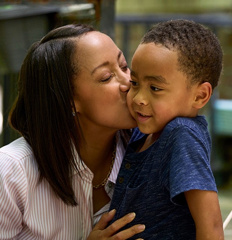 Heather kissing her son on the cheek.