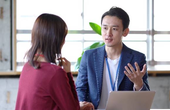 2 people discussing in front of a computer