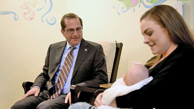 Secretary Azar sitting with parent and baby