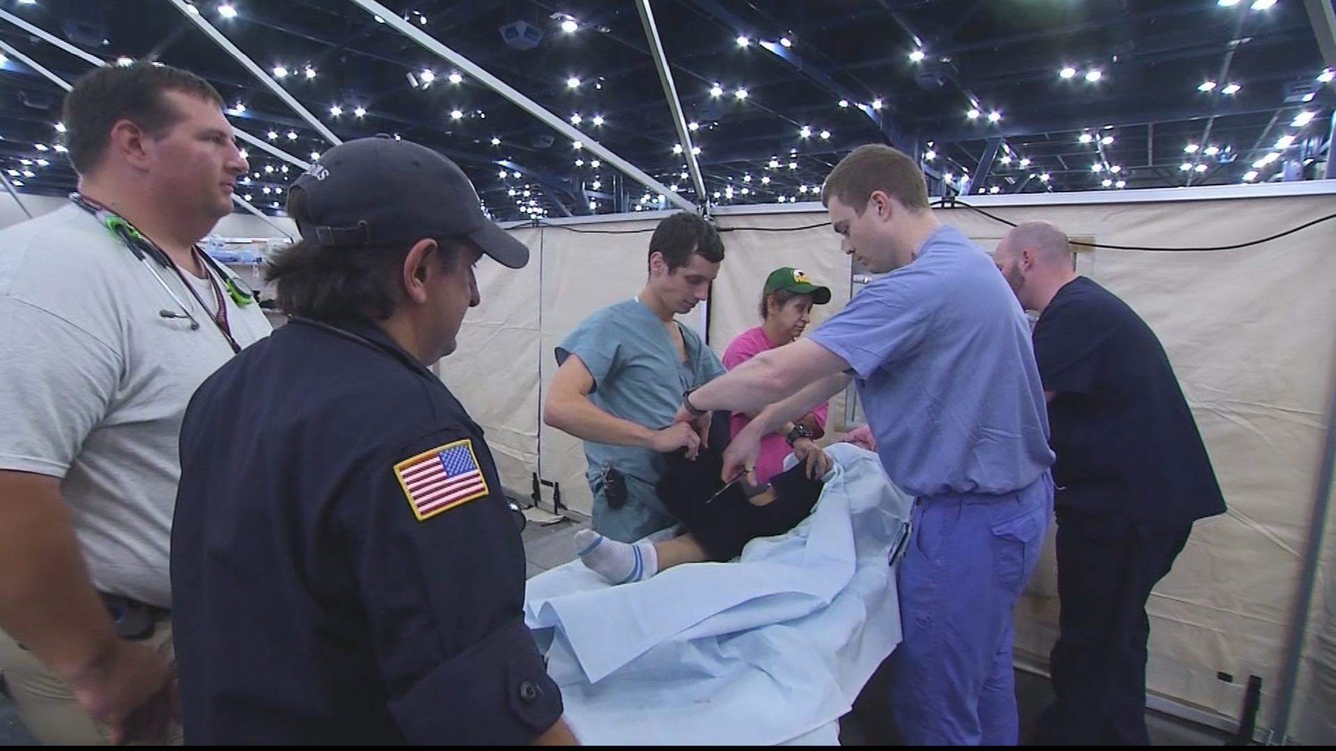 HHS personnel help a young patient at the Houston Convention Center