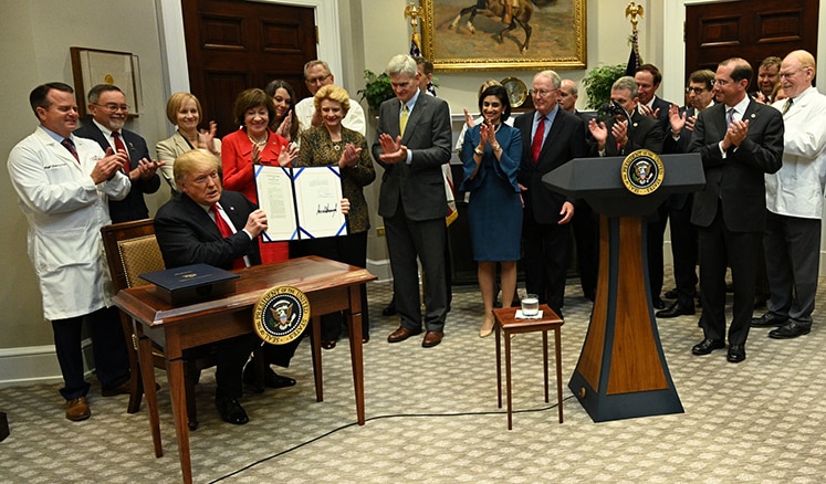 President Trump signs legislation that bans pharmacy gag clauses.