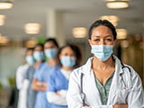 5 medical professionals standing with masks on.