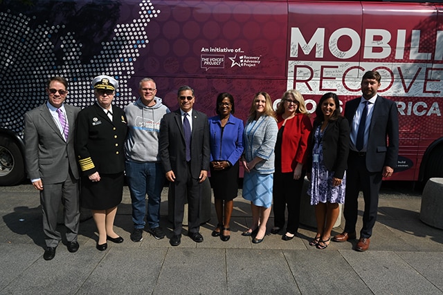 HHS leaders standing in front of the Mobilize Recovery tour bus.
