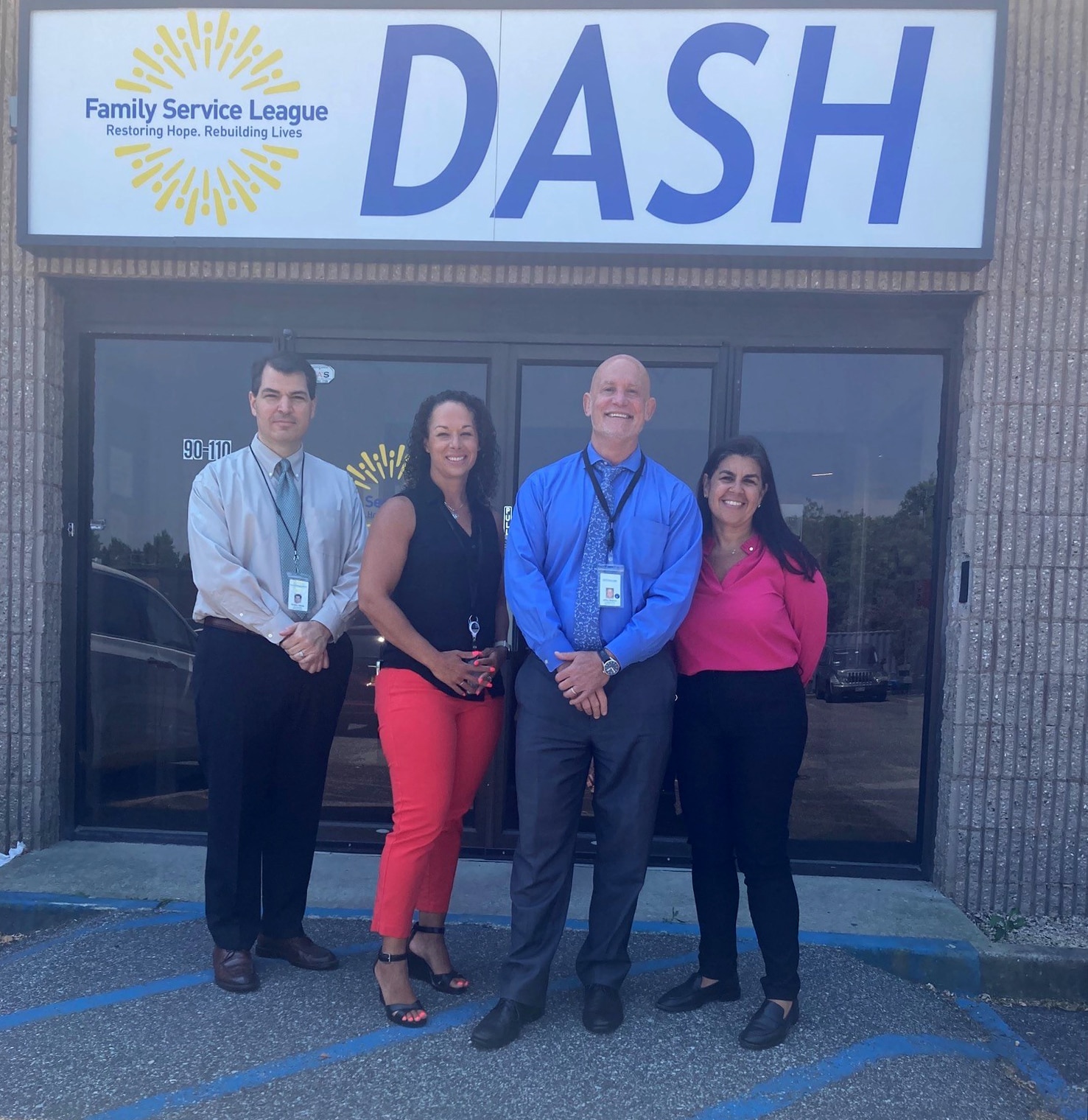 Group photo of four adults standing outside of the DASH Crisis Service Center.