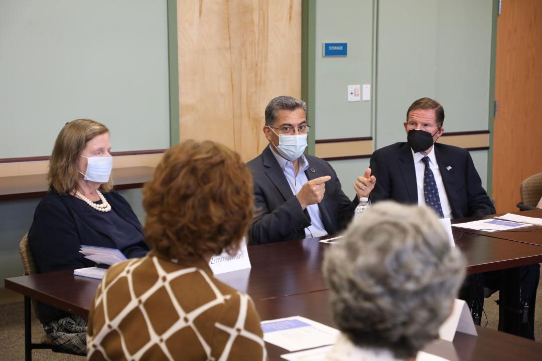 Secretary Becerra speaking with a group of people around a table