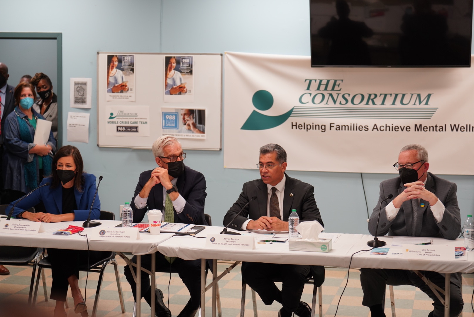 Secretary Becerra speaking with others seated during a roundtable discussion. Banner says The Consortium