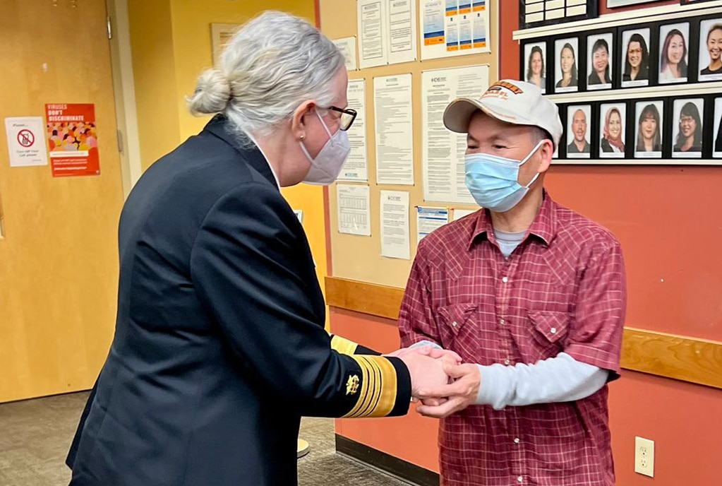 Assistant Secretary for Health Admiral Rachel Levine shakes hands with a person in a hallway.