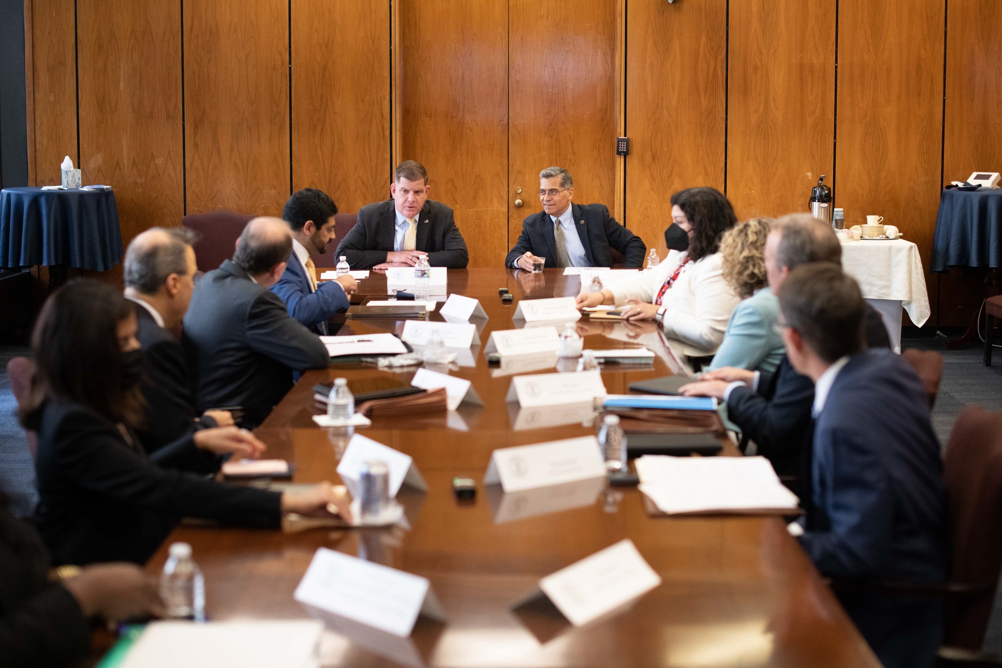 Secretary of Health and Human Services Xavier Becerra (right) and Secretary of Labor Marty Walsh (left) at conference room table with health insurance and business leaders to discuss mental health parity laws in Washington on May 3, 2022
