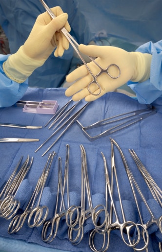 Gloved hands and surgical tools