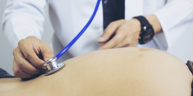 physician examines pregnant woman