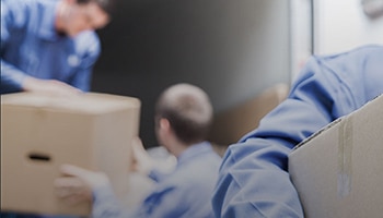 men in blue shirts moving boxes.