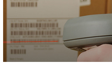  A scanner scanning the label on the side of a box.