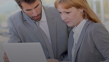 business man and woman looking at a sheet of paper.