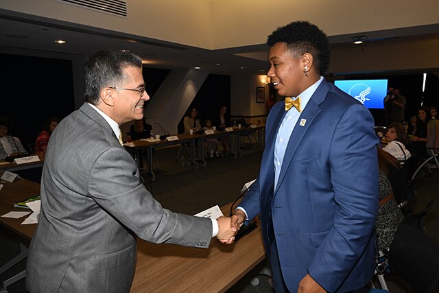 Secretary Becerra smiling while shaking hands with a roundtable participant