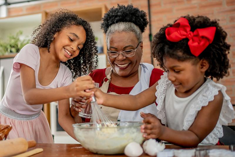 Photo of multigenerational African American family preparing a meal for the holidays.